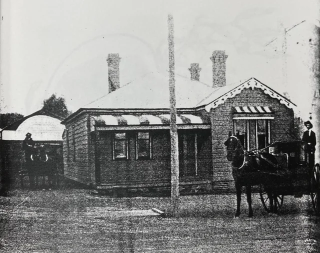 The cottage at 374 Argyle Street with its verandah, striped awnings, decorative gable and horse-drawn vehicles.