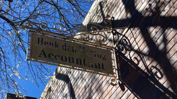 Weathered Henk den Hertog Accountant sign mounted outside 374 Argyle Street